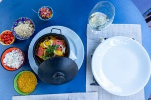 "Moqueca de Peixe com camarões, arroz de coco queimado e farofinha de banana da terra" é uma deliciosa